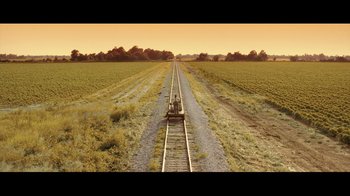 Movie still from “Side by Side” (2012), directed by Christopher Kenneally – An empty train track in the middle of an empty field; Extreme Wide shot, Overhead angle