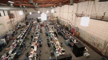 Movie still from “Side by Side” (2012), directed by Christopher Kenneally – An overhead view of an assembly room with many tables and chairs; Extreme Wide shot, High angle