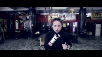 Movie still from “Side by Side” (2012), directed by Christopher Kenneally – A woman in a boxing ring with her hands wrapped in bandages; Medium shot, Low angle