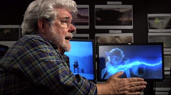 Movie still from “Side by Side” (2012), directed by Christopher Kenneally – An older man sitting in front of two computer monitors; Close Up shot, Over the shoulder angle