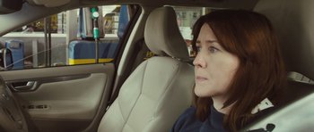 Movie still from “Sightseers” (2012), directed by Ben Wheatley – A woman sitting in the back seat of a car; Close Up shot, Over the shoulder angle