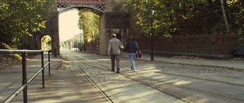 Movie still from “Sightseers” (2012), directed by Ben Wheatley – A man and a woman are walking on the sidewalk; Wide shot, High angle
