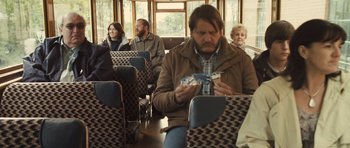 Movie still from “Sightseers” (2012), directed by Ben Wheatley – A group of people sitting on a bus; Medium shot, Over the shoulder angle