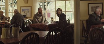 Movie still from “Sightseers” (2012), directed by Ben Wheatley – A man and a woman sitting at a table in front of a window; Medium shot, Over the shoulder angle