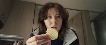 Movie still from “Sightseers” (2012), directed by Ben Wheatley – A person holding a potato chip; Extreme Close Up shot, Overhead angle