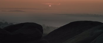 Movie still from “Sightseers” (2012), directed by Ben Wheatley – The sun is setting in the sky over the mountains; Extreme Wide shot, High angle