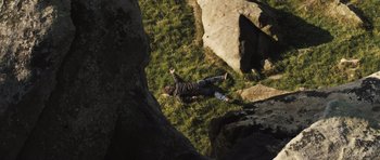 Movie still from “Sightseers” (2012), directed by Ben Wheatley – A man laying in the grass on top of a hill; Wide shot, Overhead angle