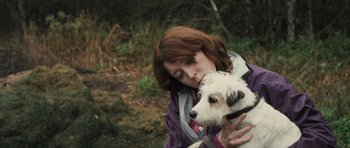Movie still from “Sightseers” (2012), directed by Ben Wheatley – A woman holding a small white dog in her arms; Close Up shot, High angle