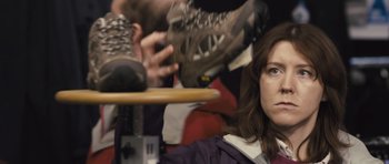 Movie still from “Sightseers” (2012), directed by Ben Wheatley – A woman sitting in front of a man with a pair of shoes; Close Up shot, Over the shoulder angle
