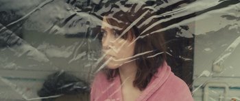 Movie still from “Sightseers” (2012), directed by Ben Wheatley – A woman in a pink robe looking out of a window; Close Up shot, Overhead angle
