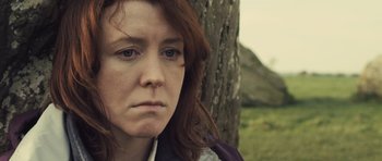 Movie still from “Sightseers” (2012), directed by Ben Wheatley – A person near a tree; Close Up shot, Low angle