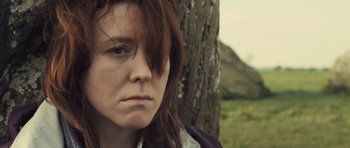 Movie still from “Sightseers” (2012), directed by Ben Wheatley – A person near a tree; Close Up shot, Low angle