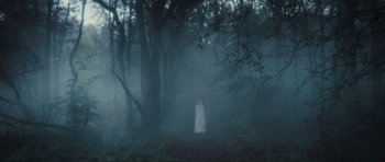 Movie still from “Sightseers” (2012), directed by Ben Wheatley – A woman in a white dress standing in the woods; Extreme Wide shot, Low angle