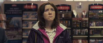 Movie still from “Sightseers” (2012), directed by Ben Wheatley – A woman standing in front of a shelf in a store; Close Up shot, Over the shoulder angle