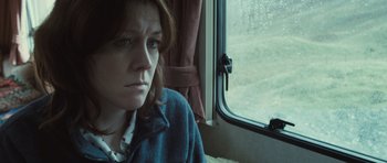 Movie still from “Sightseers” (2012), directed by Ben Wheatley – A woman sitting in front of a train window; Close Up shot, Low angle
