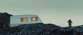 Movie still from “Sightseers” (2012), directed by Ben Wheatley – An rv parked on top of a pile of garbage; Extreme Wide shot, Low angle