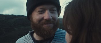 Movie still from “Sightseers” (2012), directed by Ben Wheatley – A man with a long beard wearing a black hat; Close Up shot, Over the shoulder angle