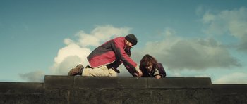 Movie still from “Sightseers” (2012), directed by Ben Wheatley – A man and a woman on a ledge with a sky in the background; Wide shot, Low angle