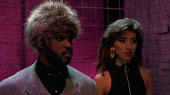 Movie still from “Sign 'o' the Times” (1987), directed by Albert Magnoli – A man and a woman standing next to each other in front of a brick wall; Close Up shot, Low angle