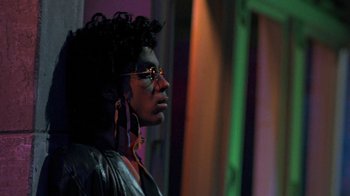 Movie still from “Sign 'o' the Times” (1987), directed by Albert Magnoli – A man with dreadlocks and glasses looking to his left; Close Up shot, Low angle