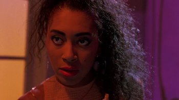 Movie still from “Sign 'o' the Times” (1987), directed by Albert Magnoli – A person with curly black hair; Close Up shot, Over the shoulder angle