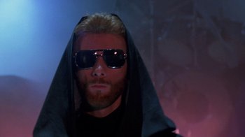 Movie still from “Sign 'o' the Times” (1987), directed by Albert Magnoli – A man with a beard and sunglasses is wearing a hood; Close Up shot, Low angle