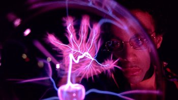 Movie still from “Sign 'o' the Times” (1987), directed by Albert Magnoli – A man with glasses is holding a purple light in his hand; Extreme Close Up shot, Overhead angle