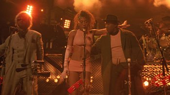 Movie still from “Sign 'o' the Times” (1987), directed by Albert Magnoli – A man and a woman standing next to each other; Medium shot, Low angle