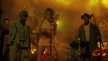 Movie still from “Sign 'o' the Times” (1987), directed by Albert Magnoli – A group of people performing on a stage; Medium shot, Low angle