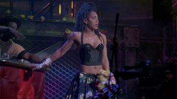 Movie still from “Sign 'o' the Times” (1987), directed by Albert Magnoli – A woman in a black corset holding a sword; Medium shot, Low angle