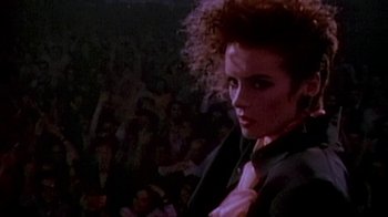 Movie still from “Sign 'o' the Times” (1987), directed by Albert Magnoli – A person wearing a suit and tie; Close Up shot, Low angle