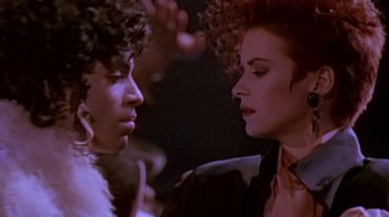 Movie still from “Sign 'o' the Times” (1987), directed by Albert Magnoli – Two people are talking in a dark room; Close Up shot, Over the shoulder angle