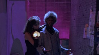 Movie still from “Sign 'o' the Times” (1987), directed by Albert Magnoli – A man and a woman are holding a light up heart; Medium shot, Low angle