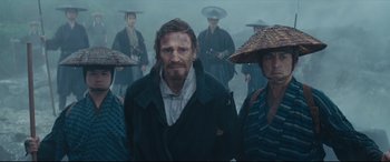 Movie still from “Silence” (2016), directed by Martin Scorsese – A group of people standing next to each other in the fog; Medium shot, Low angle