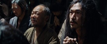 Movie still from “Silence” (2016), directed by Martin Scorsese – Two asian men sitting next to each other in a dark room; Close Up shot, Low angle