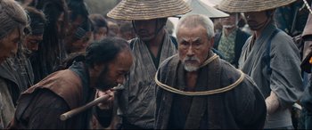 Movie still from “Silence” (2016), directed by Martin Scorsese – A group of men standing next to each other on a field; Medium shot, Low angle