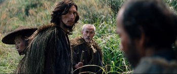 Movie still from “Silence” (2016), directed by Martin Scorsese – Two men standing next to each other in the grass; Medium shot, Over the shoulder angle