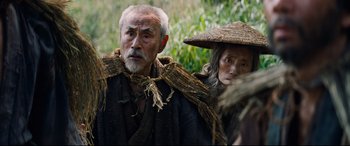 Movie still from “Silence” (2016), directed by Martin Scorsese – An old man and a woman in a straw hat; Medium shot, Low angle