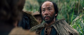 Movie still from “Silence” (2016), directed by Martin Scorsese – A man with a beard wearing a straw hat; Close Up shot, Low angle