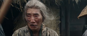 Movie still from “Silence” (2016), directed by Martin Scorsese – An old woman with long gray hair is looking at the camera; Close Up shot, Low angle