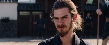 Movie still from “Silence” (2016), directed by Martin Scorsese – A person with long hair and a beard; Close Up shot, Over the shoulder angle