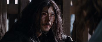 Movie still from “Silence” (2016), directed by Martin Scorsese – A person with long black hair; Close Up shot, Low angle