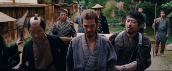 Movie still from “Silence” (2016), directed by Martin Scorsese – A group of people in traditional japanese garb; Medium shot, Over the shoulder angle