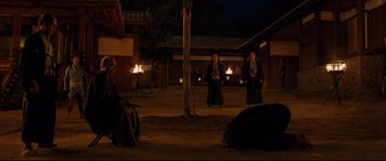 Movie still from “Silence” (2016), directed by Martin Scorsese – Two men in traditional garb are standing in the dark; Wide shot, Over the shoulder angle