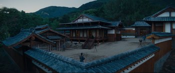 Movie still from “Silence” (2016), directed by Martin Scorsese – A man standing in front of a house; Extreme Wide shot, High angle