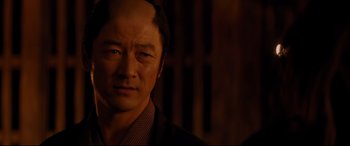 Movie still from “Silence” (2016), directed by Martin Scorsese – A person wearing a suit and tie; Close Up shot, Over the shoulder angle