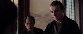 Movie still from “Silence” (2016), directed by Martin Scorsese – A man in a black robe and another man in a black robe; Close Up shot, Over the shoulder angle