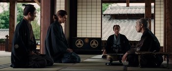 Movie still from “Silence” (2016), directed by Martin Scorsese – A man and a woman sitting on the ground; Medium shot, Over the shoulder angle