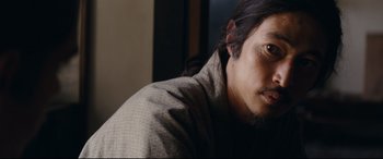 Movie still from “Silence” (2016), directed by Martin Scorsese – A person wearing a robe; Close Up shot, Over the shoulder angle