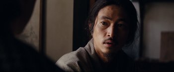 Movie still from “Silence” (2016), directed by Martin Scorsese – A person wearing a robe; Close Up shot, Over the shoulder angle